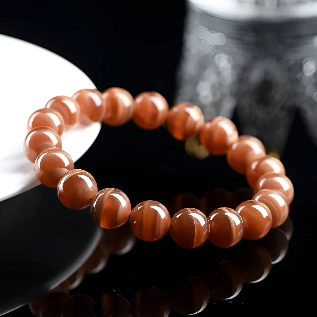 Natural Old Mine Rhodochrosite round bead bracelet on wrist, showing manganese spar colour.