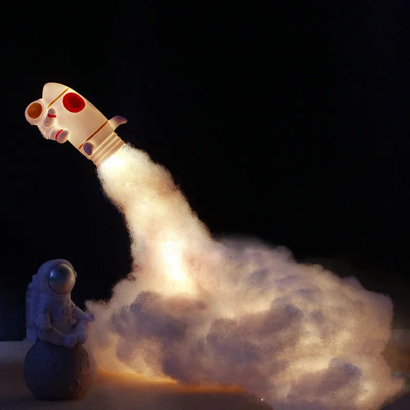 DIY Astronaut Rocket night light kit parts displayed with warm LED glow, showing rocket model, chassis, and string lights.