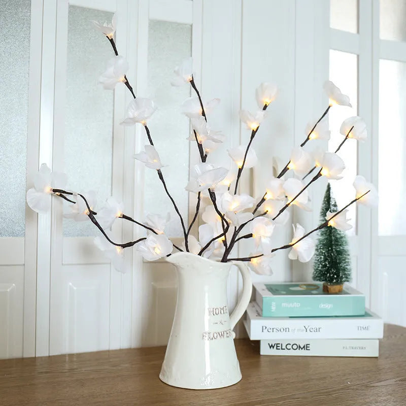 Pink phalaenopsis orchid branch decorative light with 20 LEDs, standing 65cm tall on a table.