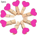 Set of five handmade wooden heart-shaped decorative clips in assorted colours.