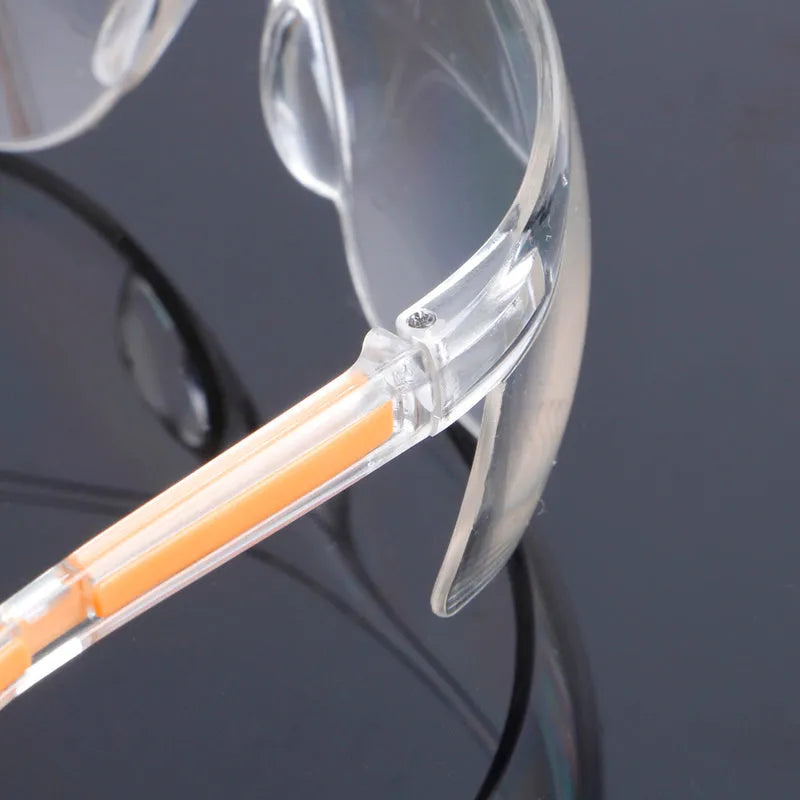Transparent polycarbonate safety goggles with yellow frame for industrial and lab eye protection.