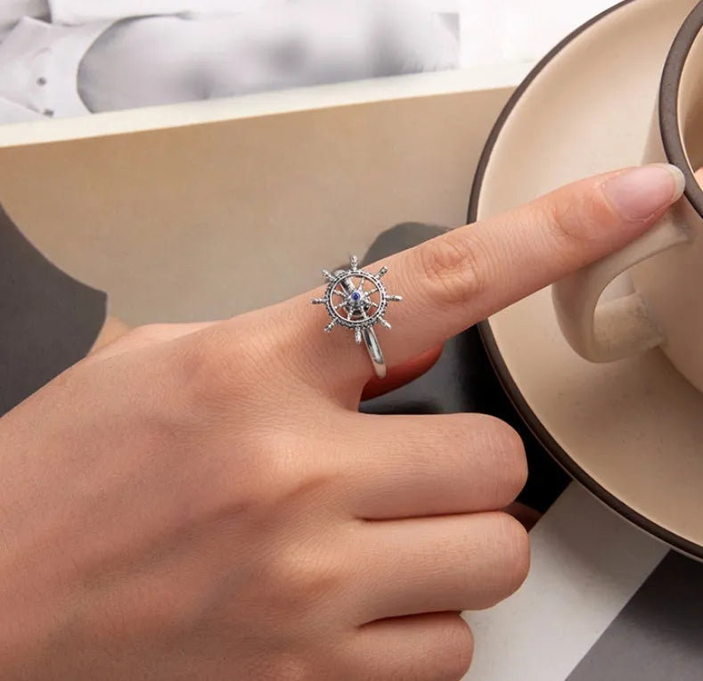 Retro women's silver ring with rotatable rudder design and inlaid zircon stone on open mouth band.