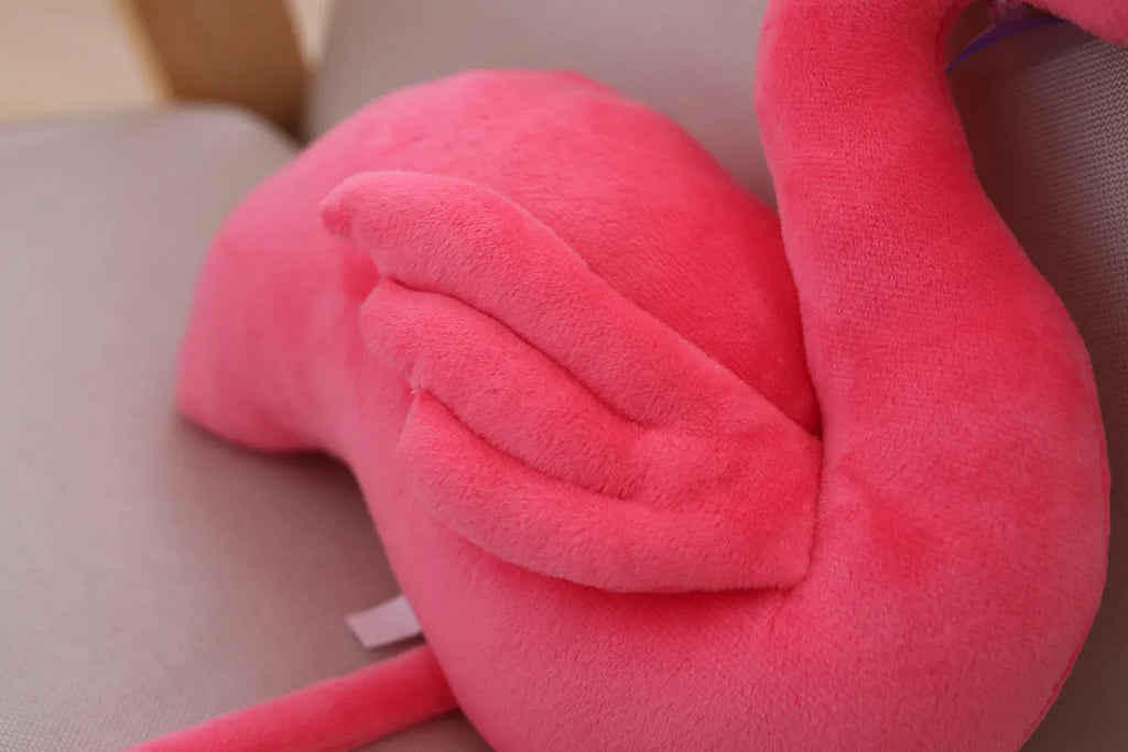 Pink flamingo plush toy with short plush fabric, filled with PP cotton, sitting on a surface