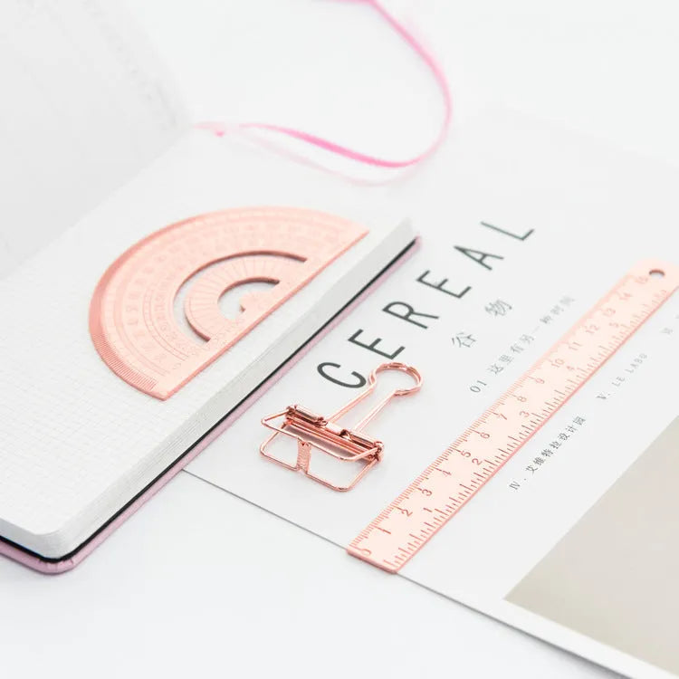 Rose gold and yellow stainless steel ruler set with protractor, triangle, and straightedge in transparent pocket