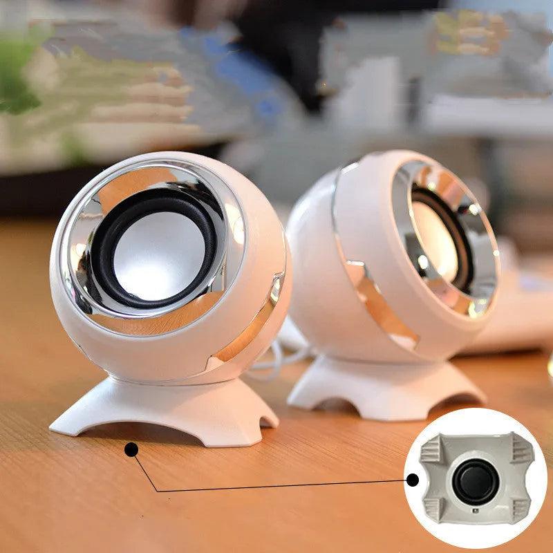Black and gold USB-powered desktop computer speakers beside laptop showing compact 10cm dimensions