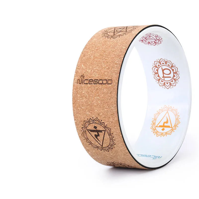 Cork yoga wheel in classic black, 32cm diameter, on a yoga mat in a home studio