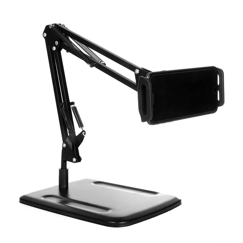 Black universal phone stand with long rotating metal arm and heavy circular base on a wooden desk.