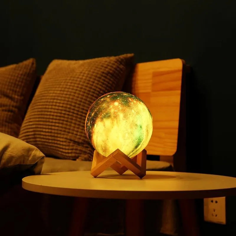 3D printed white moon lamp night light glowing on a surface next to its remote control.