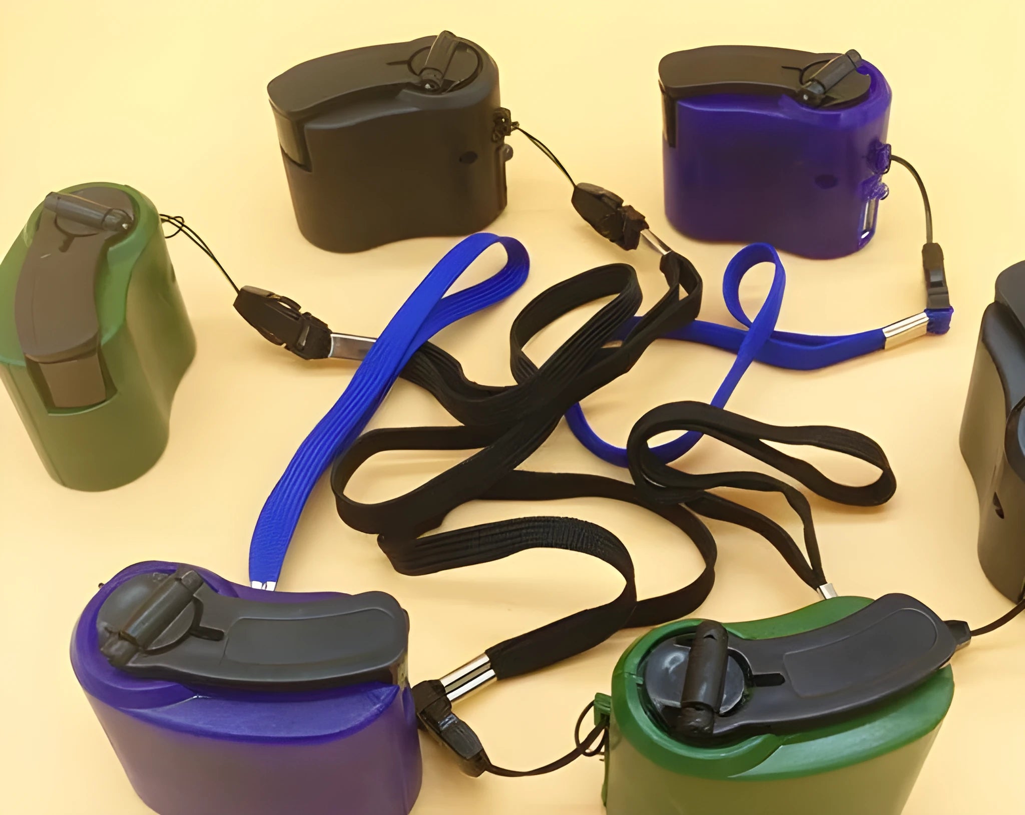 USB hand dynamo charger in green and blue showing winding handle and LED indicator