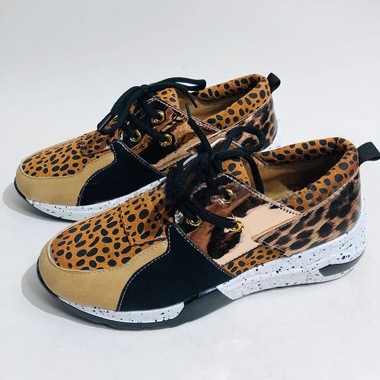 Women's casual wedge heel sneakers in suede, showing round toe and low-cut profile on a wooden floor.