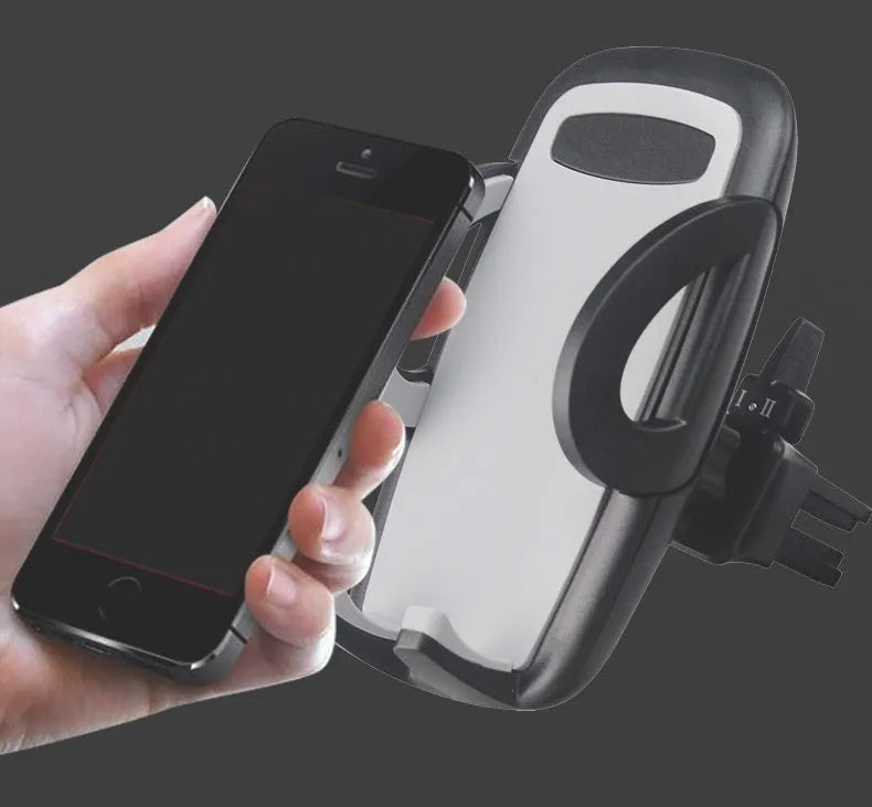 Black plastic car phone holder mounted on air conditioning outlet holding smartphone