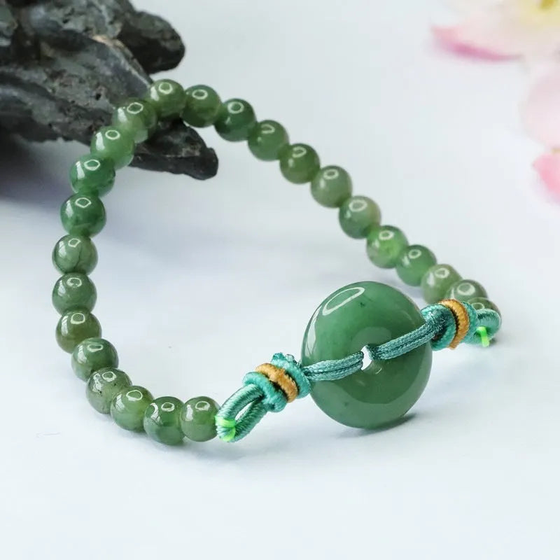 Emerald green jade bracelet with safety buckle closure and star charm on wrist