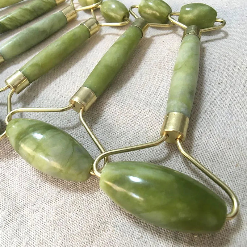 Natural Xiuyu jade double-end roller with green stone, hand-polished finish, large and small wheels on a flat surface