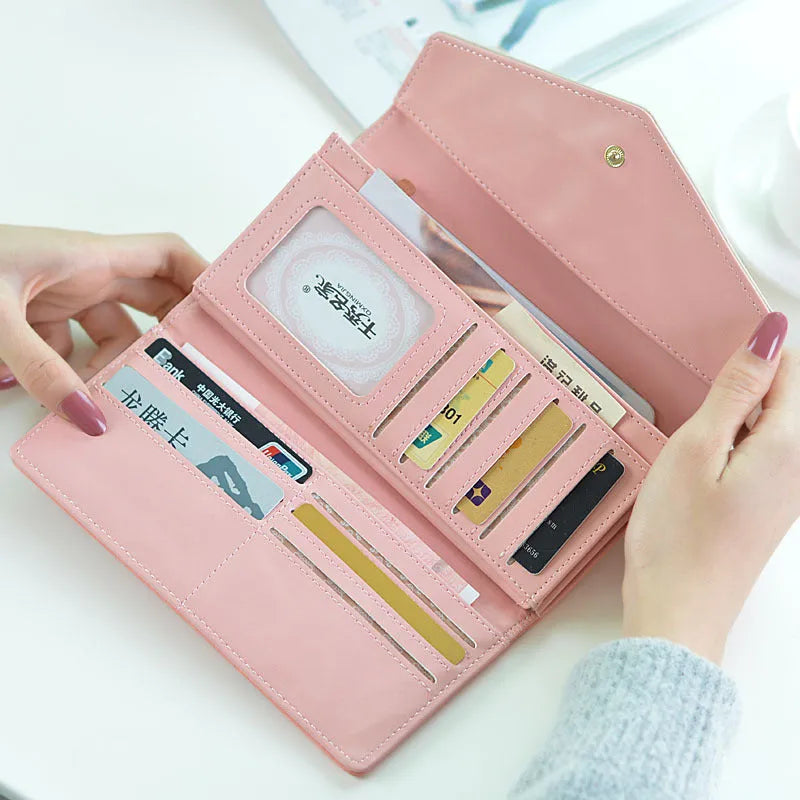 Women's black PU leather three-fold wallet with a metal clip closure, shown open.