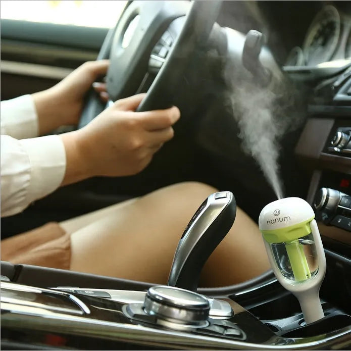 Blue portable car humidifier with rotating nozzle on a car dashboard