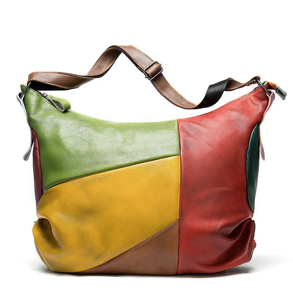 Brown cowhide leather crossbody travel bag showing main compartment open next to a 15-inch laptop and A4 magazine.