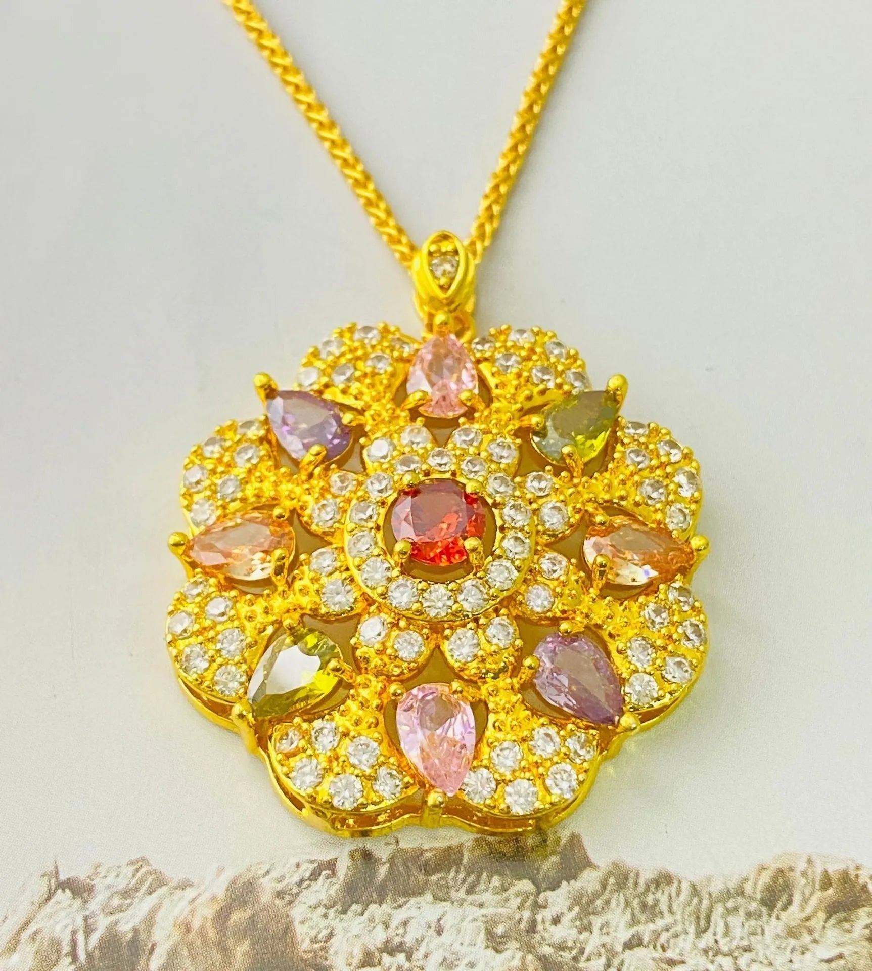 Close-up of a women's floral-shaped zircon pendant necklace in a gold colour finish with a matching chain.