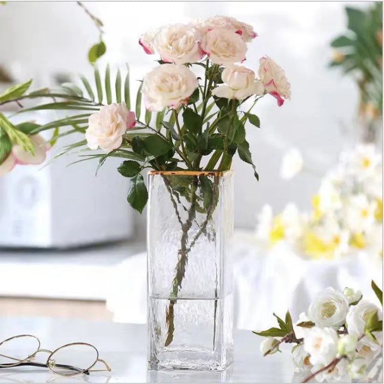 Transparent gold-painted glass vase on plain background