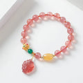 Women's Nine Tail Fox style strawberry quartz crystal beaded bracelet on wrist