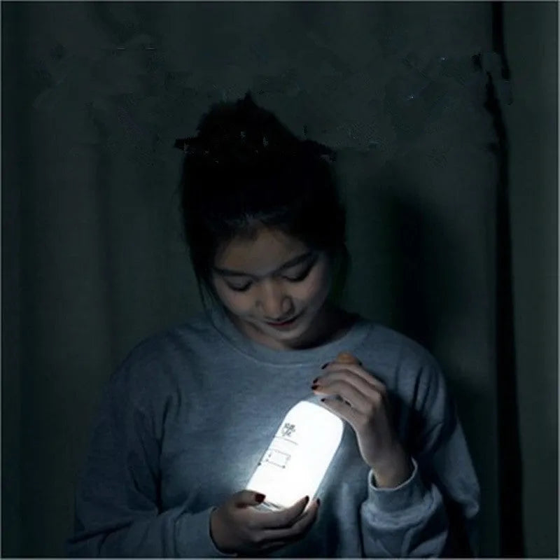 White milk bottle shaped LED nightlight on a wooden surface, USB rechargeable, with a 30-minute timer and DIY message panel