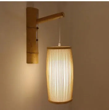 Small bamboo plaited wall light with natural finish, shown mounted on a wall.
