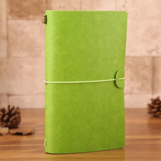 Vintage A6 PU leather traveller notebook journal in black, with elastic closure, on a wooden table