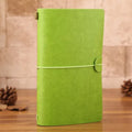 Vintage A6 PU leather traveller notebook journal in black, with elastic closure, on a wooden table