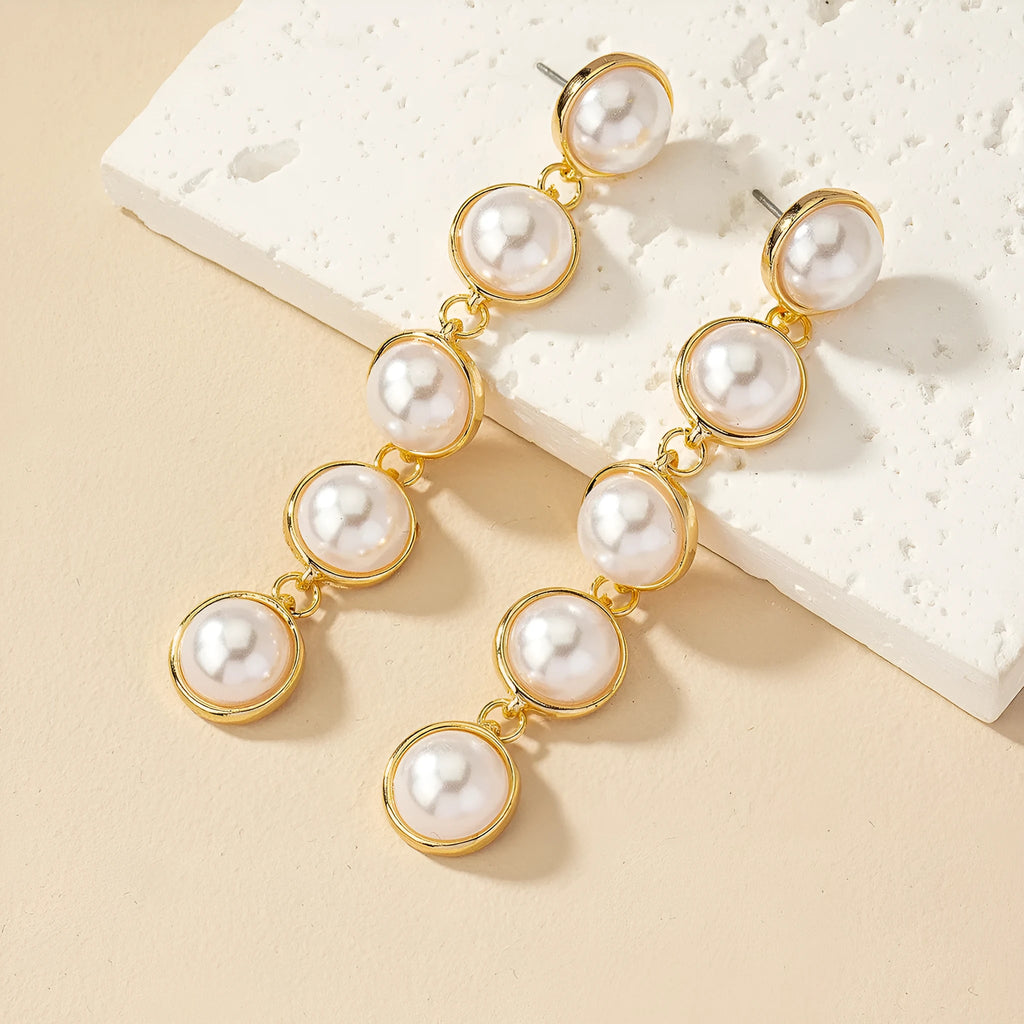White long pearl tassel drop earrings made of electroplated metal with water flow design on white background