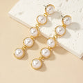 White long pearl tassel drop earrings made of electroplated metal with water flow design on white background