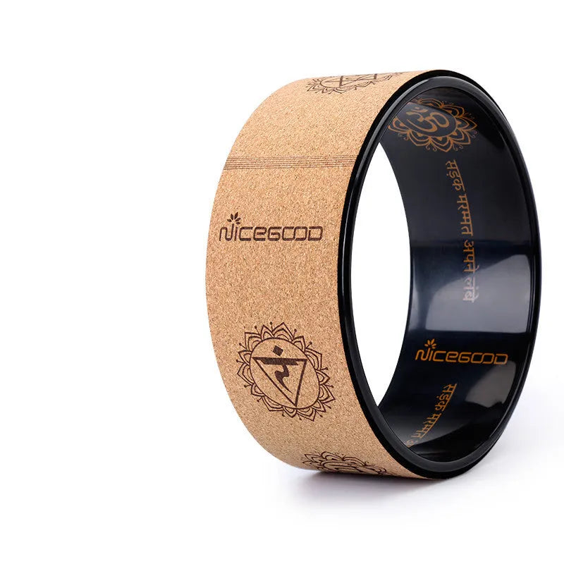 Cork yoga wheel in classic black, 32cm diameter, on a yoga mat in a home studio