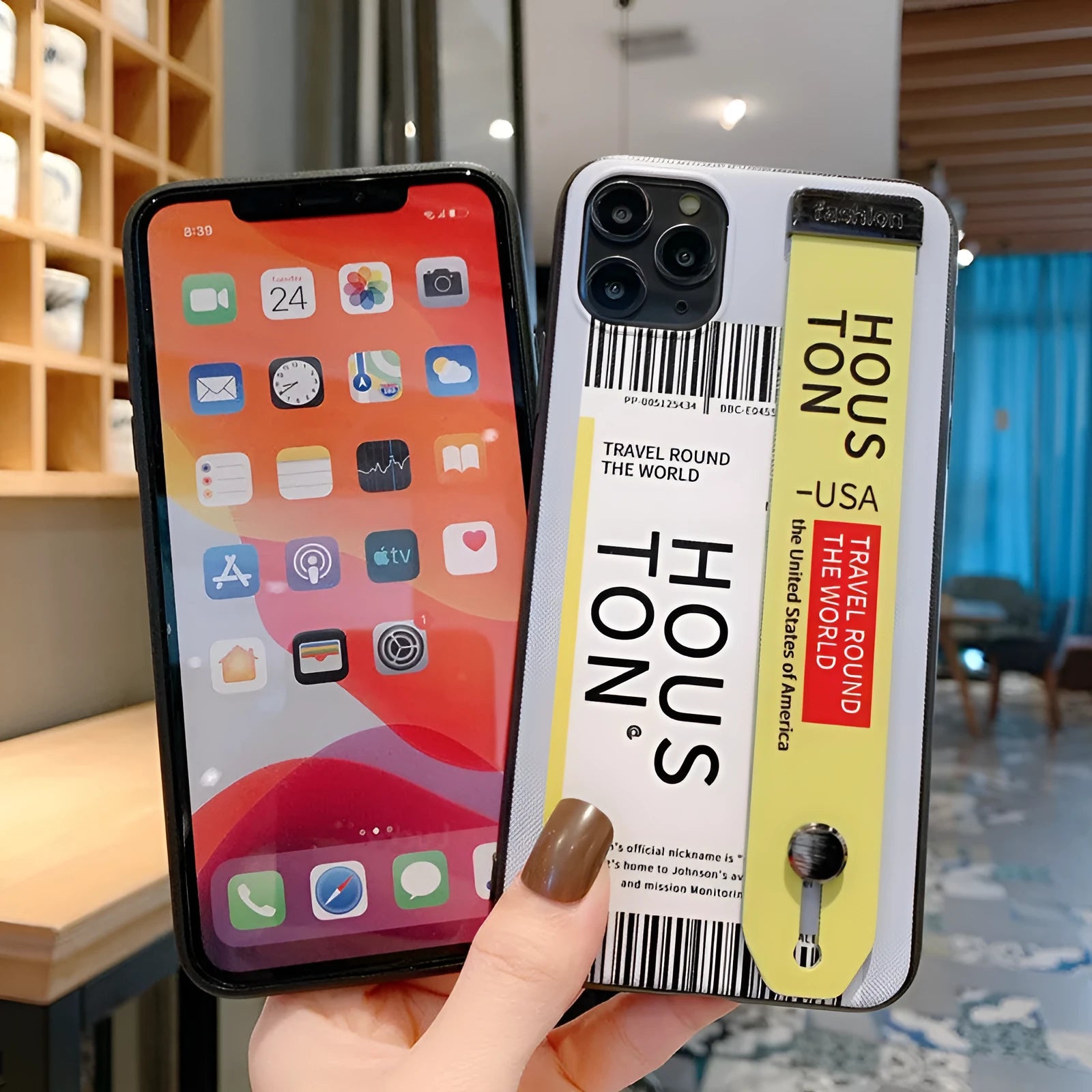 Red TPU+PC iPhone back cover case with a black wristband attached, lying on a white surface.