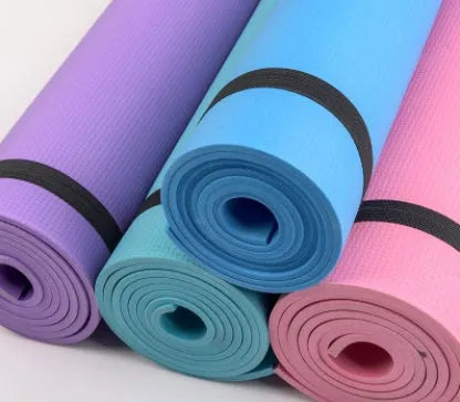 Red EVA yoga mat showing thickness, next to a blue mat, on a wooden floor.