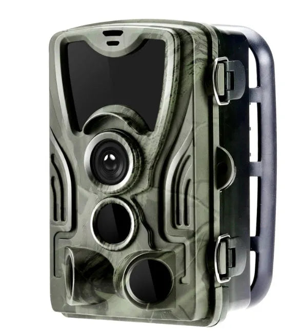 Green outdoor trail camera with lens and infrared LEDs, shown with belt strap for mounting on a tree.
