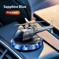 Silver metal solar-powered helicopter car air freshener with rotating blades on a dashboard