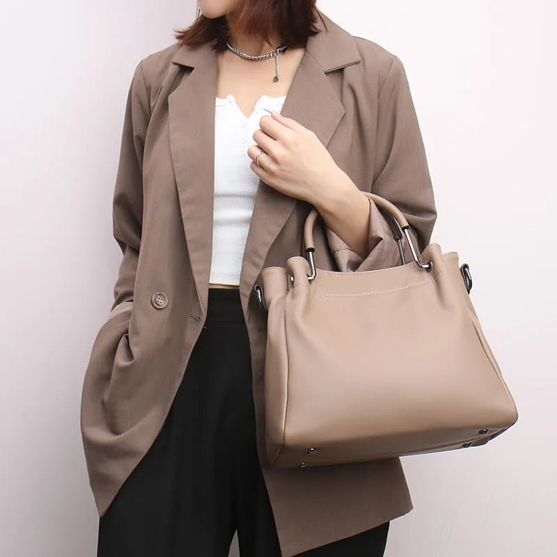 Leisure soft leather bucket bag in black with slit pocket and visible sewing thread detail for commuting
