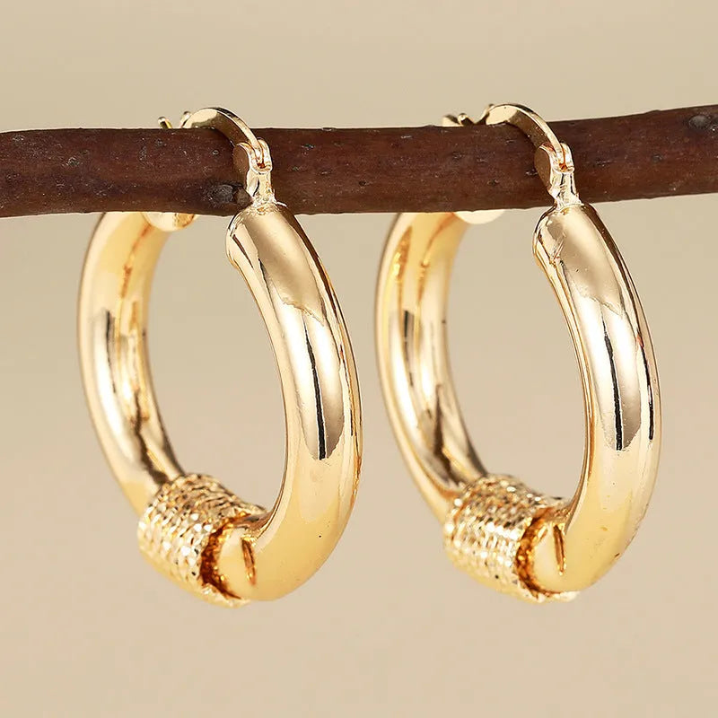 Geometric ring-shaped copper ear clips for women in a polished golden finish.