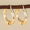 Geometric ring-shaped copper ear clips for women in a polished golden finish.