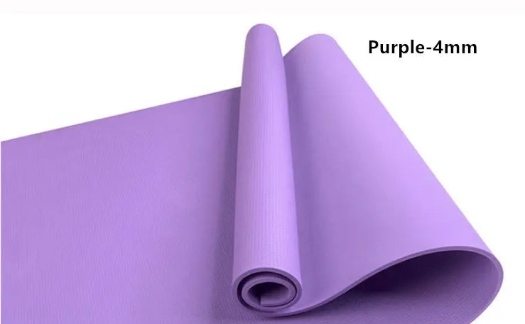 Red EVA yoga mat showing thickness, next to a blue mat, on a wooden floor.
