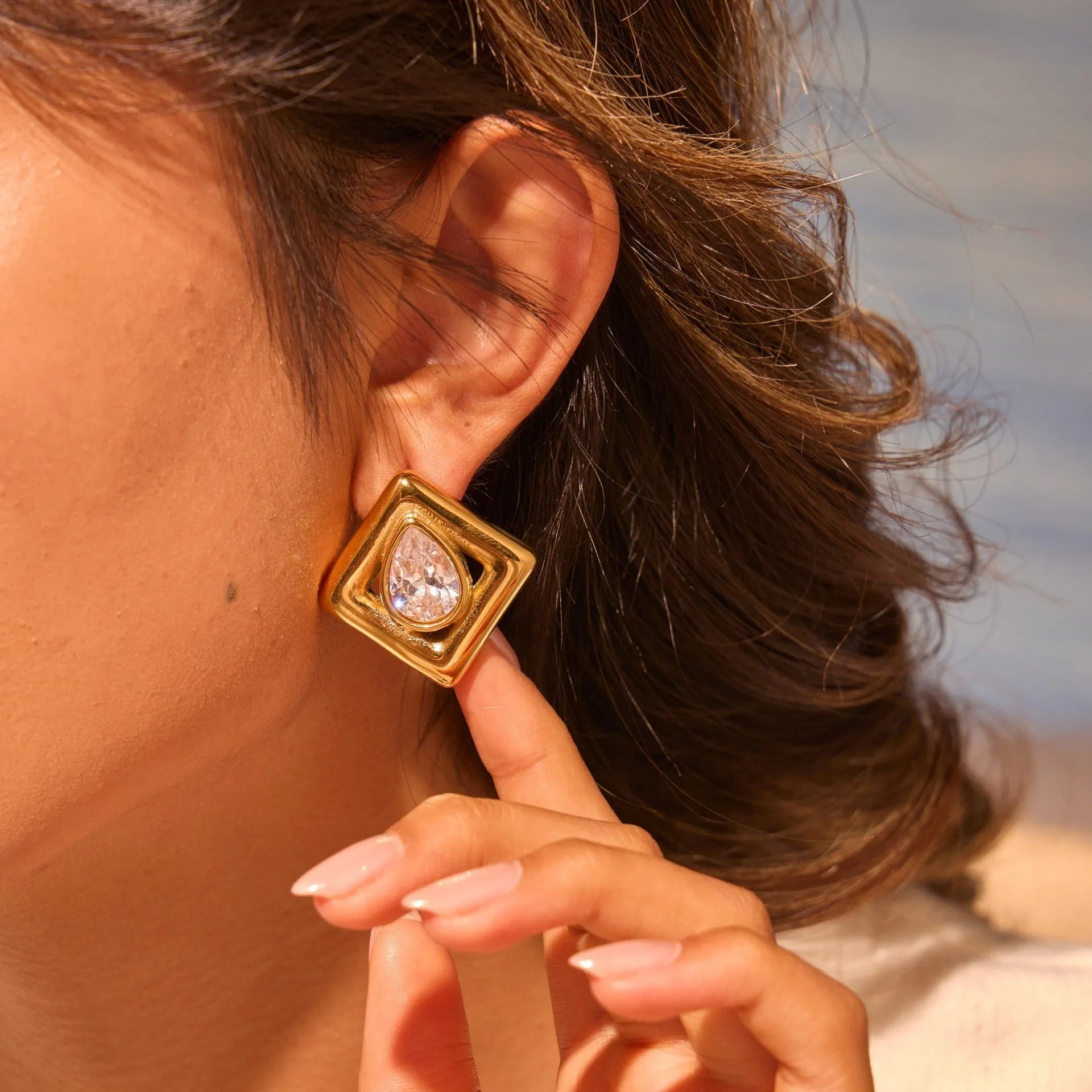 Gold geometric water drop design stud earrings with zircon accents on stainless steel