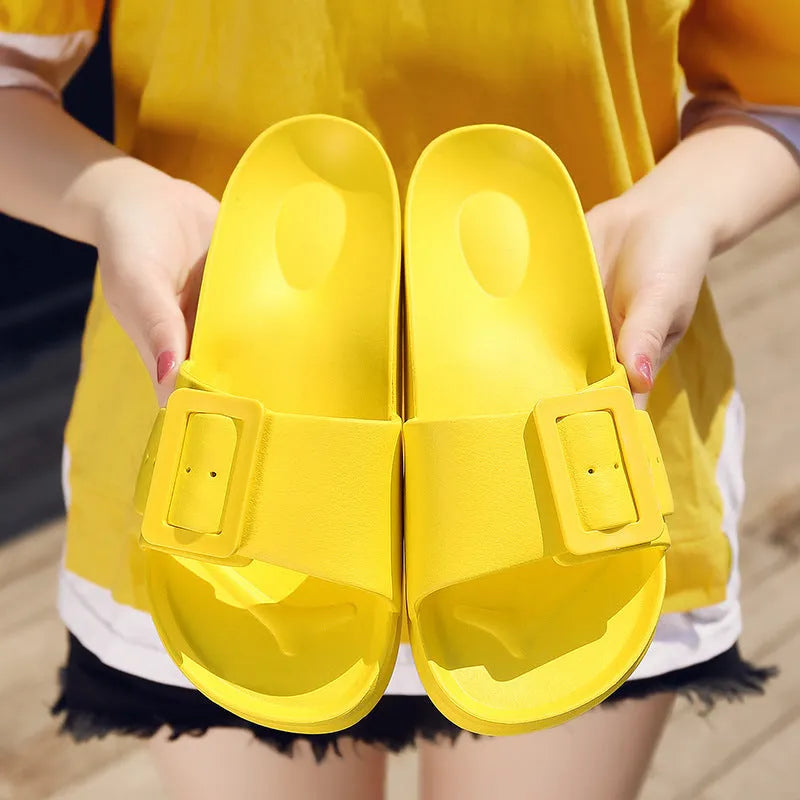 Women's grey blue flip-flop slippers with a silver adjustable buckle on the strap.