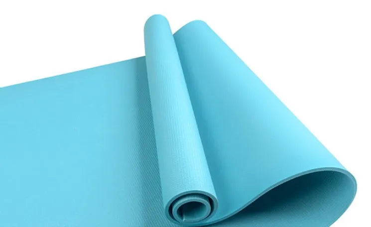 Red EVA yoga mat showing thickness, next to a blue mat, on a wooden floor.