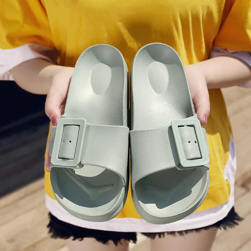 Women's grey blue flip-flop slippers with a silver adjustable buckle on the strap.