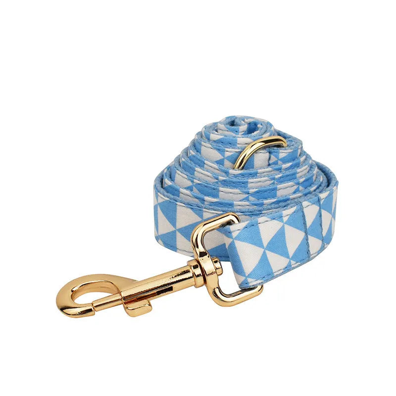Blue cloth dog vest set with matching collar, leash, and bow tie on a white background