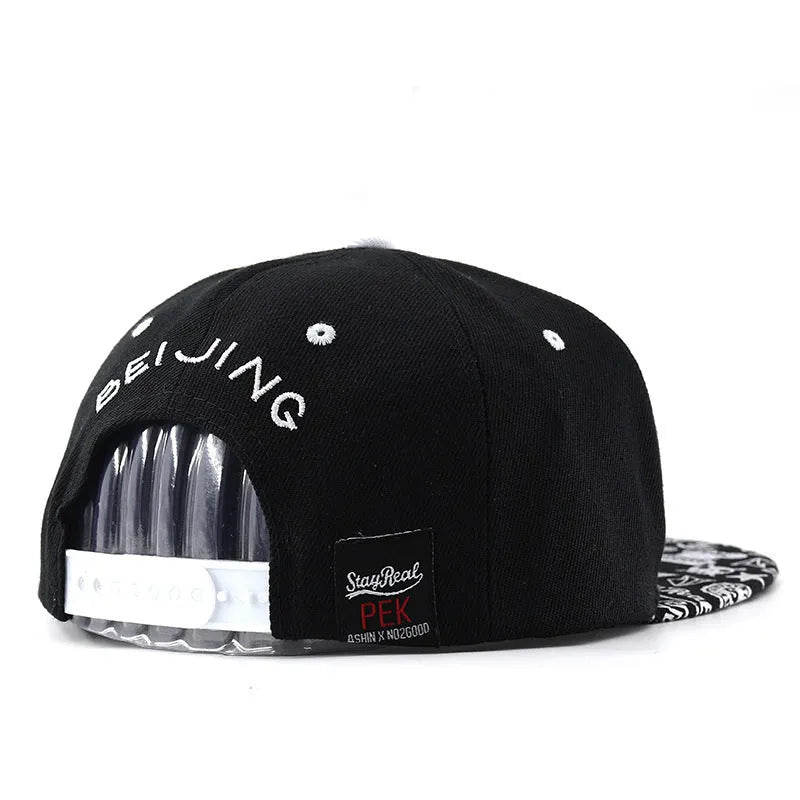 Black cotton baseball cap with white embroidered lettering on the front, showing adjustable back strap.