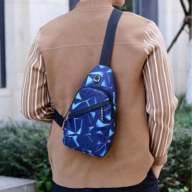 Men's blue print sling chest crossbody bag showing earphone hole and zipper pocket.
