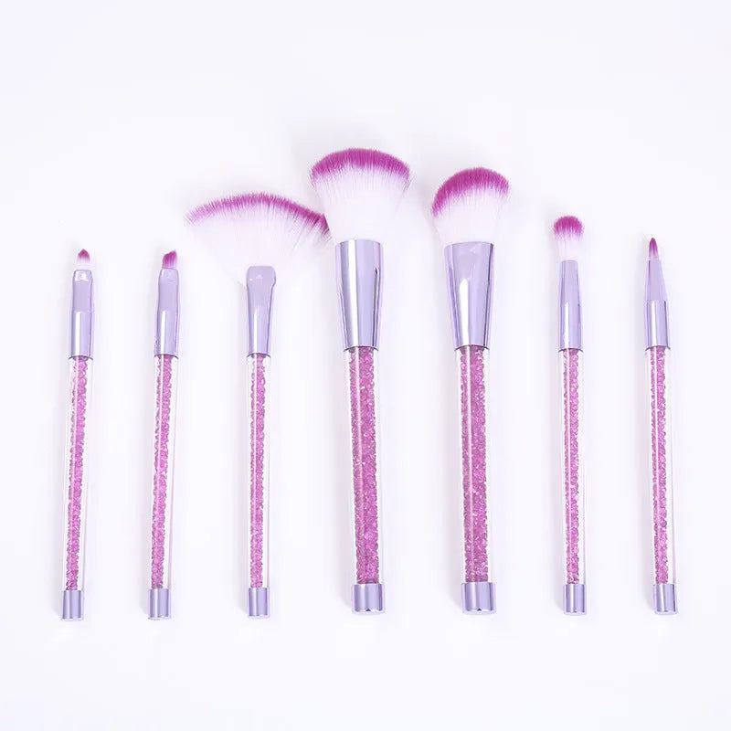Set of 7 makeup brushes with pink handles, black bristles, and long plastic handles on a light background