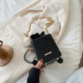 Small green women's bucket bag with a metal chain strap, shown worn cross-body, with zip open revealing interior ID pocket.