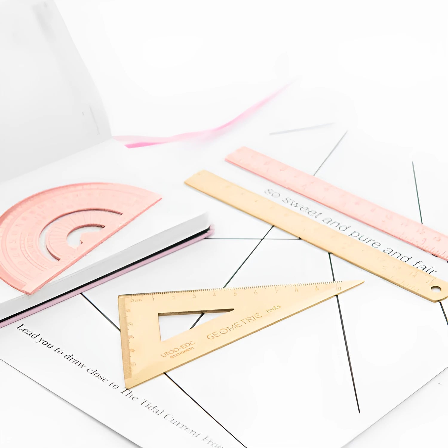 Rose gold and yellow stainless steel ruler set with protractor, triangle, and straightedge in transparent pocket