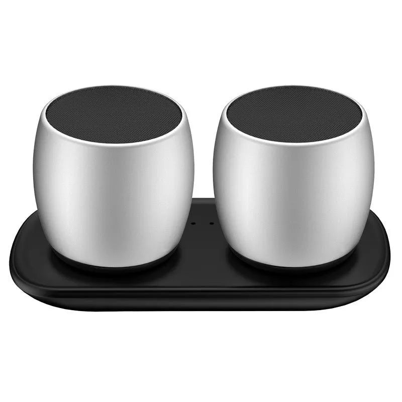 Creative Bluetooth speaker pair in black and silver on a charging base