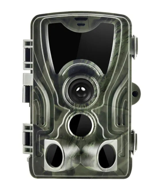 Green outdoor trail camera with lens and infrared LEDs, shown with belt strap for mounting on a tree.